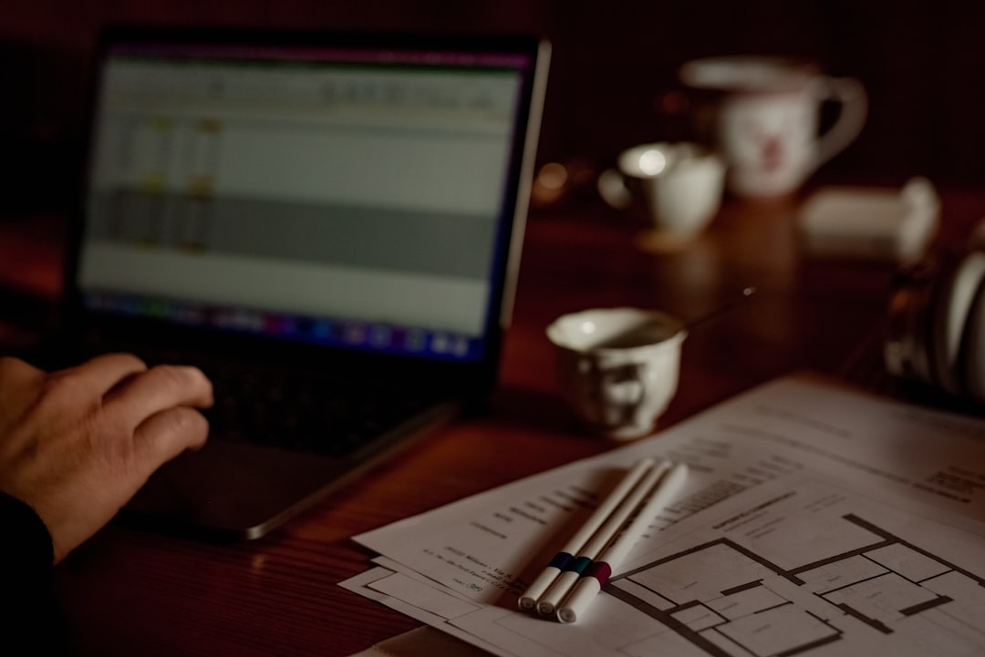 A top-down view of hands on a clean desk, reviewing house-related documents and a calculator, symbolizing financial planning for a home sale.